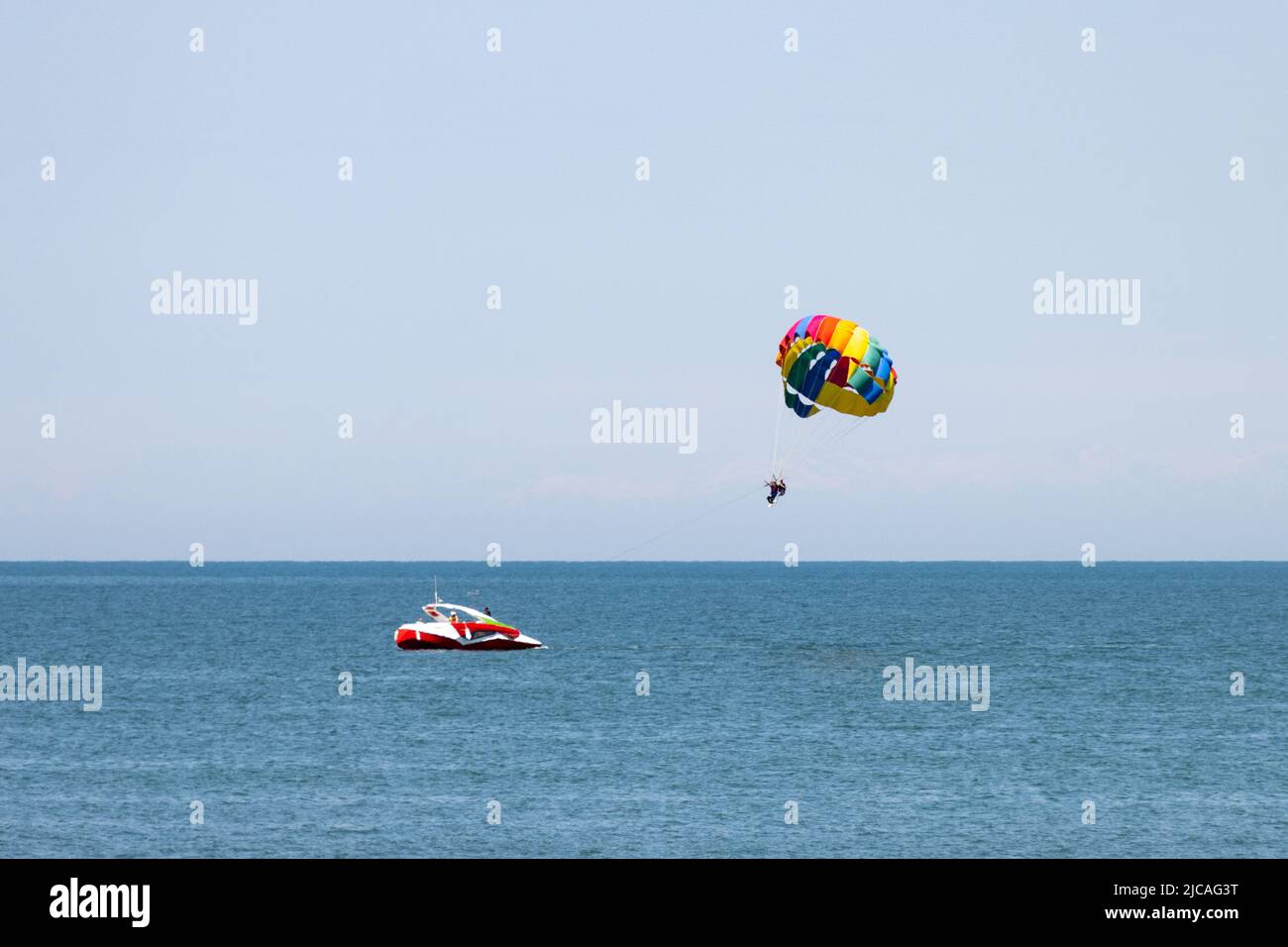 A sea parachute towed by a speedboat. Drag Boat parasailing. Stock Photo