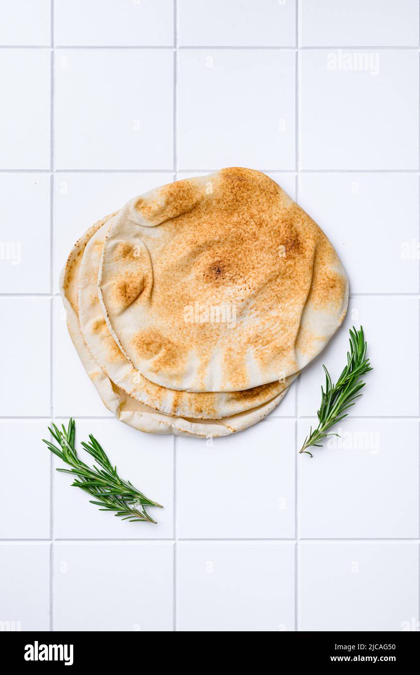 Freshly baked pita bread, on white ceramic squared tile table