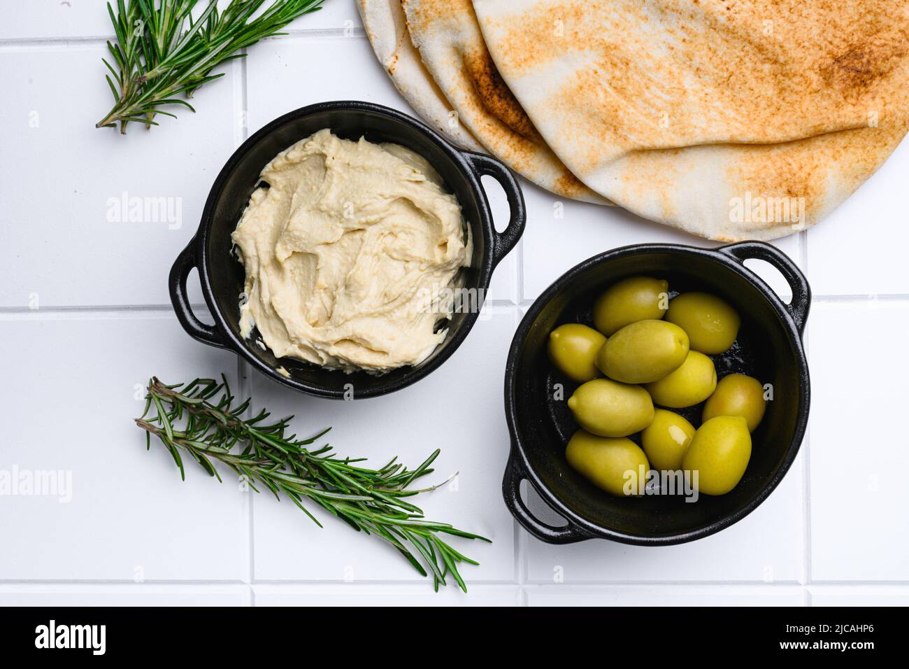 Hummus and wheat flatbread, on white ceramic squared tile table
