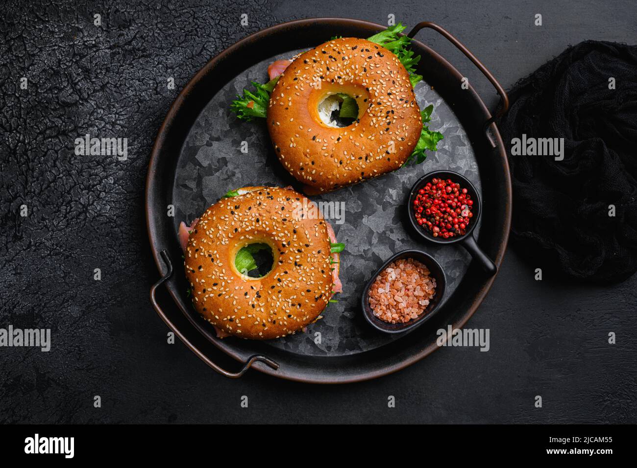 Bagel sandwich with salmon, on black dark stone table background, top ...