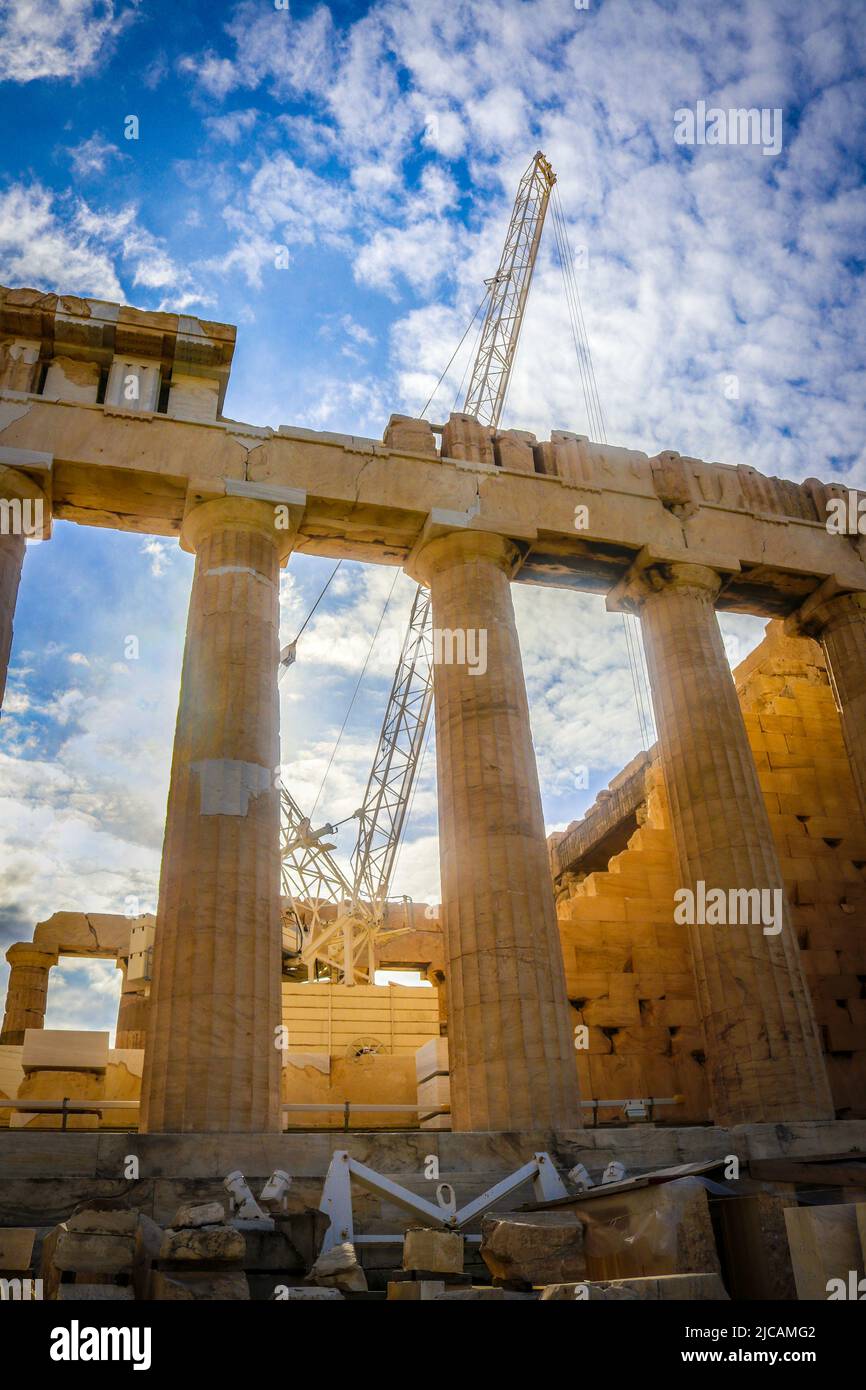 Parthenon on Acropolis in Athens under construction with tall crane under beautiful sky with sun shinning through Stock Photo