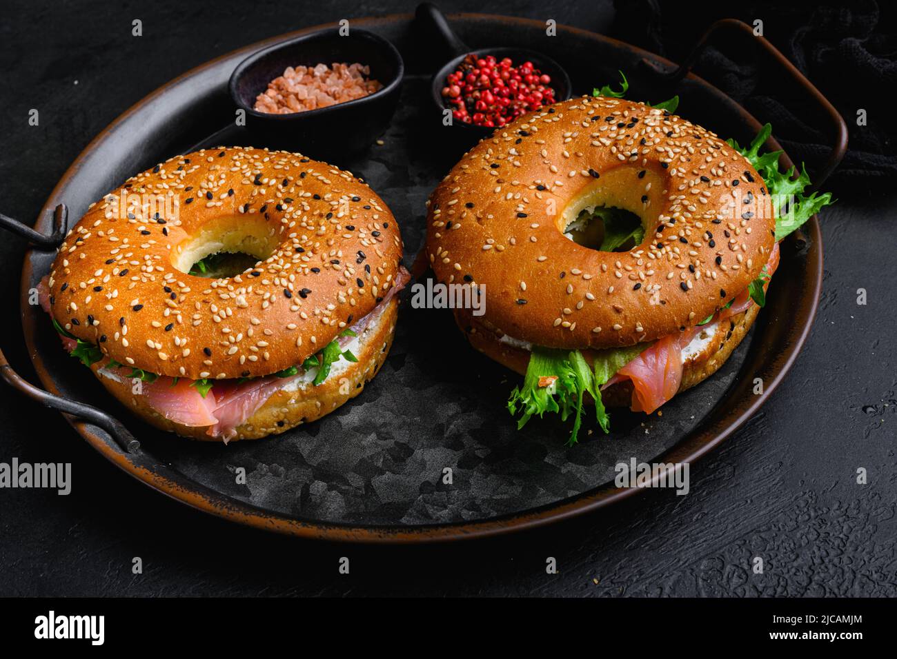 Fresh Smoked Salmon And Cream Cheese Bagel, on black dark stone table ...