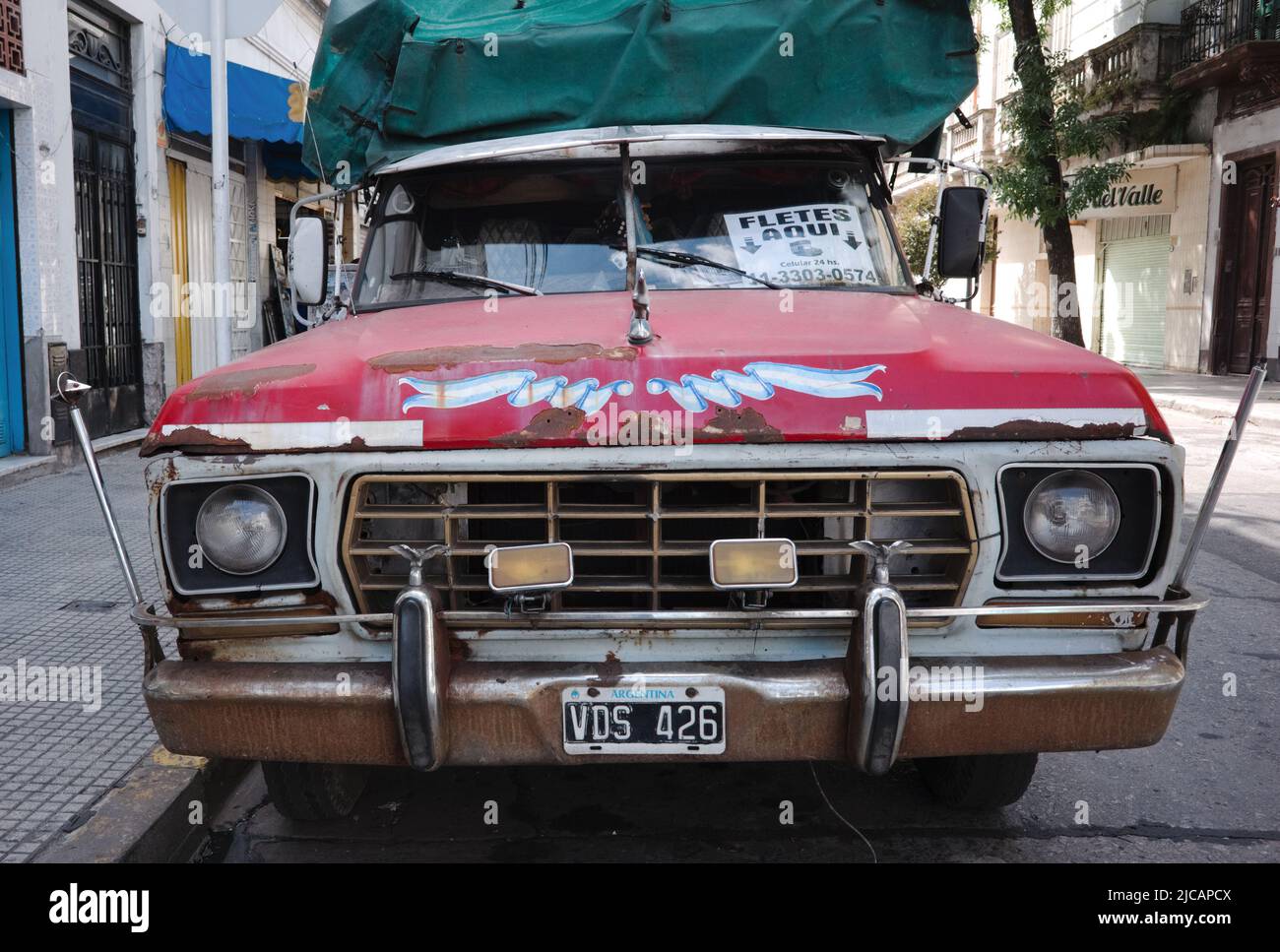 Buenos Aires, Argentina - January, 2020: Front view of old Ford F-100 pickup truck with red hood, rust on hood and bumper and argentinian license plat Stock Photo