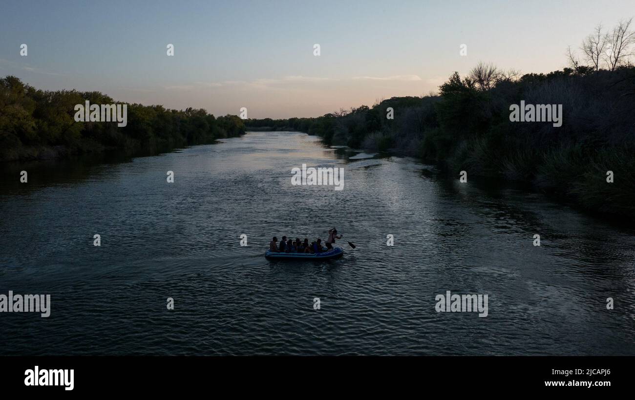 Asylum seeking migrants from Central and South America are smuggled on a raft across the Rio Grande river into the United States from Mexico in Roma Creek, Texas, U.S., June 10, 2022. Picture taken with a drone on June 10, 2022. REUTERS/Adrees Latif Stock Photo