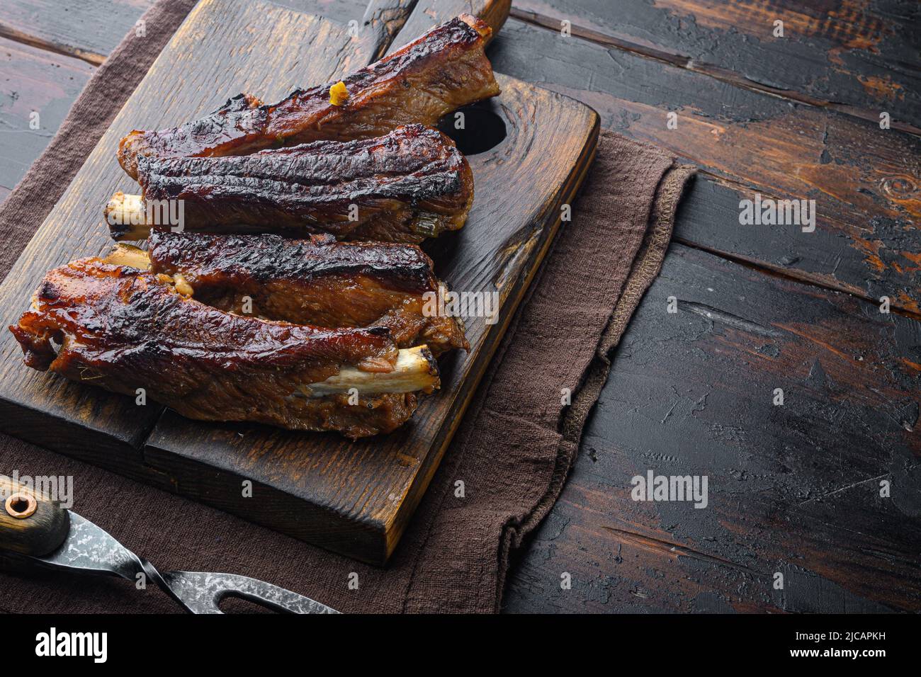 Grilled barbecue pork ribs, on wooden serving board, with barbeque ...