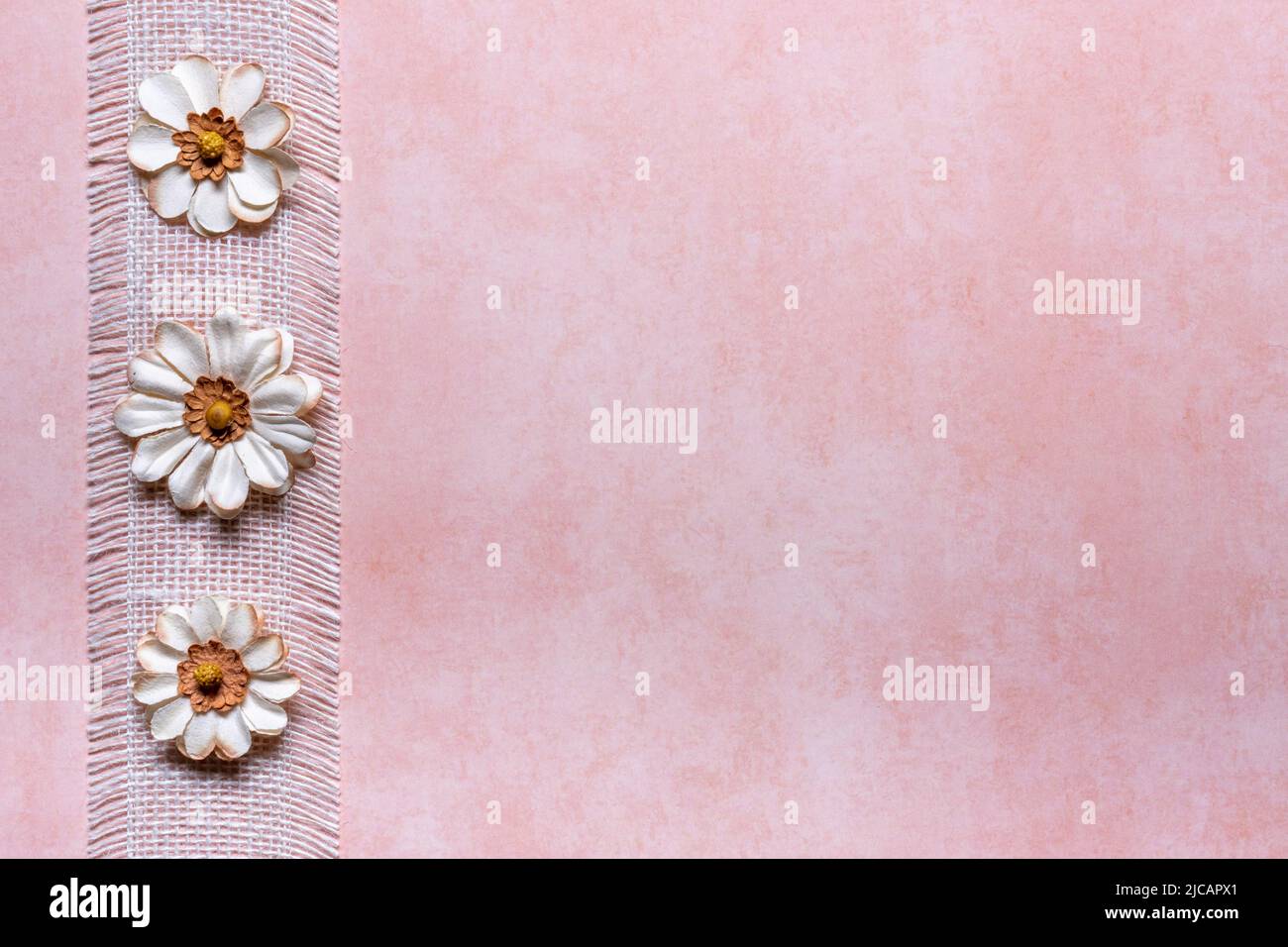 peach textured background with white burlap ribbon and 3 flower left
