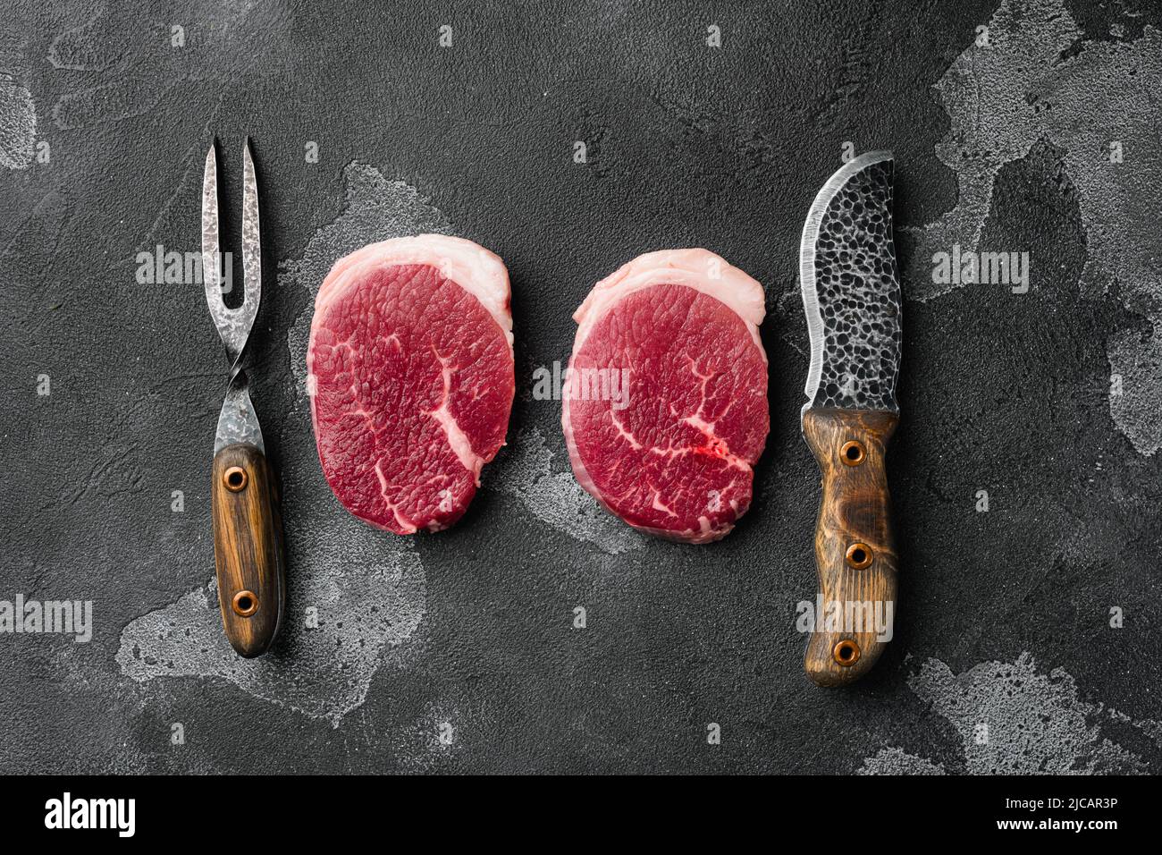 Fresh beef steak sliced, on black dark stone table background, top view ...
