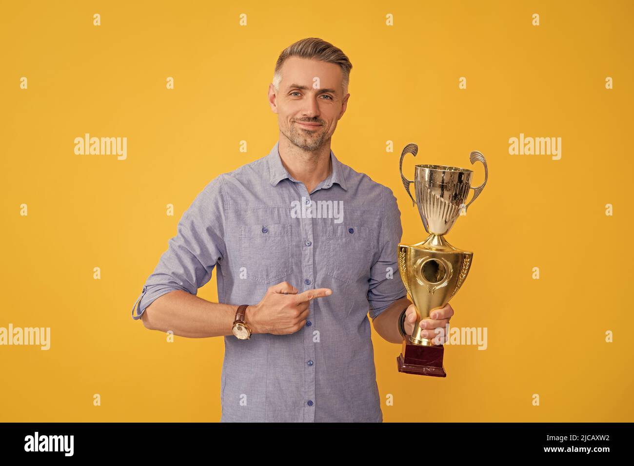 mature man pointing finger golden cup. achievement award. motivation of business success. Stock Photo