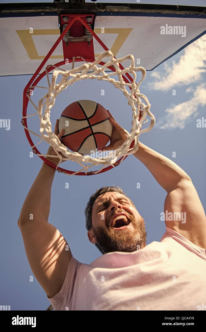 successful man player throw basketball ball through basket, success