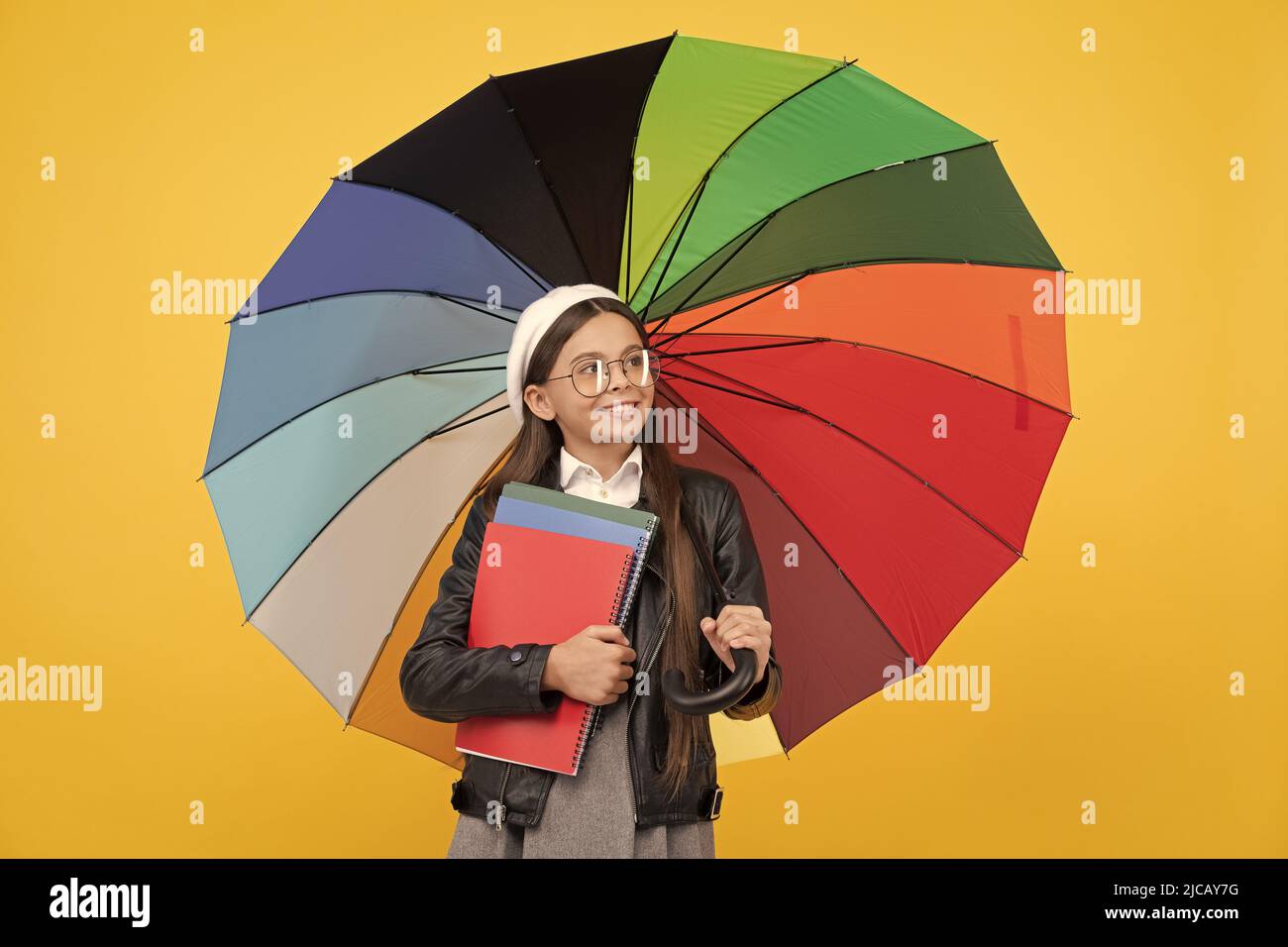 happy teen girl under colorful umbrella in autumn season hold notebook, brightness. Stock Photo
