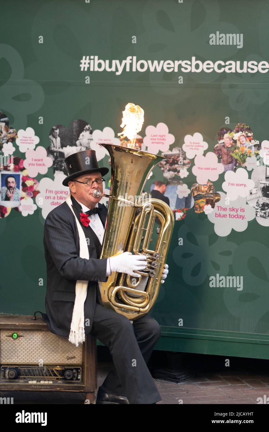 Flaming Tuba: Christopher, a street entertainer and busker playing a tuba which shoots out fire Stock Photo