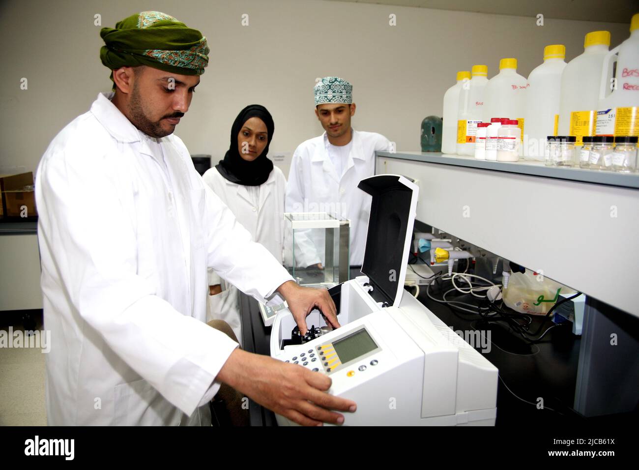 Science laboratory with male and female students and teacher, Oman Stock Photo