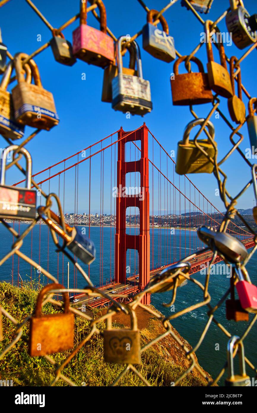 Sunset light on fence covered in locks with opening to stunning Golden