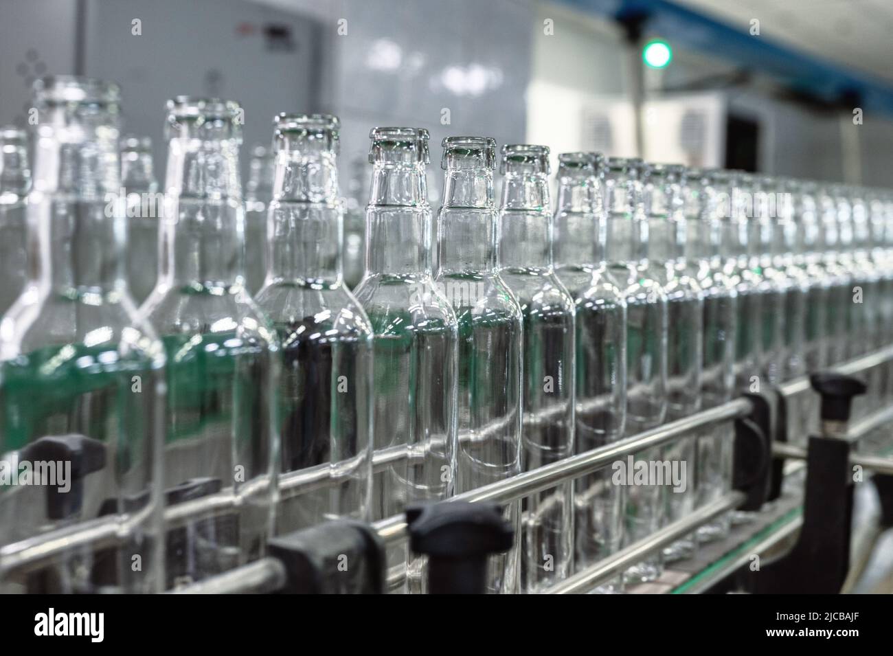 Production line transports empty glass bottles for alcohol Stock Photo