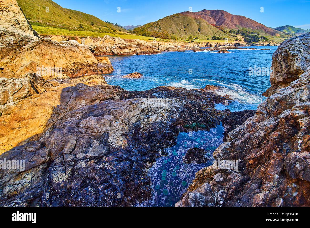 Stunning hidden tide pool by west coast cliffs and ocean Stock Photo