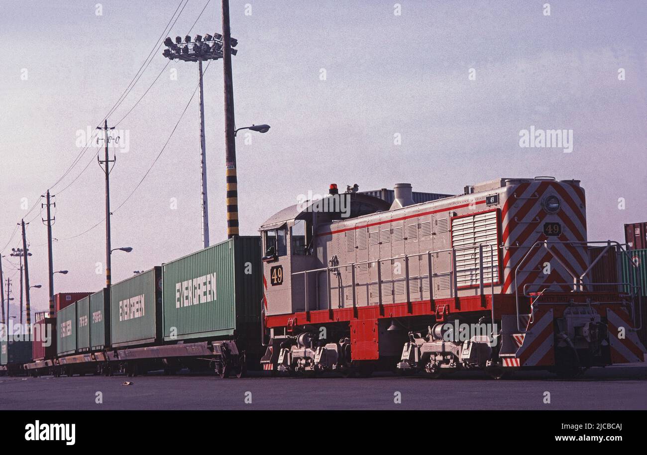 train pulls cars with shipping containers on them in San Francisco California, 1980s Stock Photo
