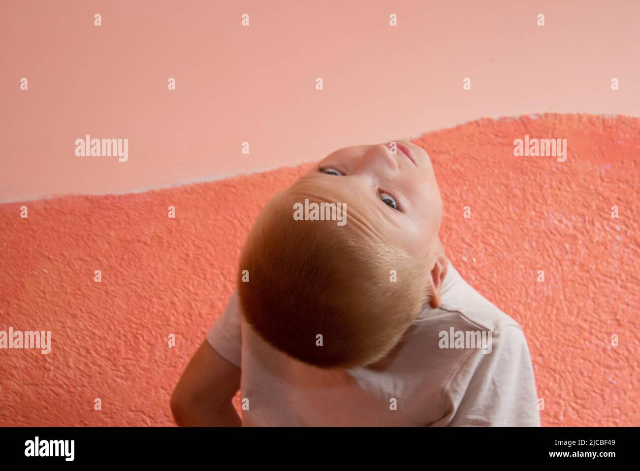 child turned his head to the back and looks up Stock Photo