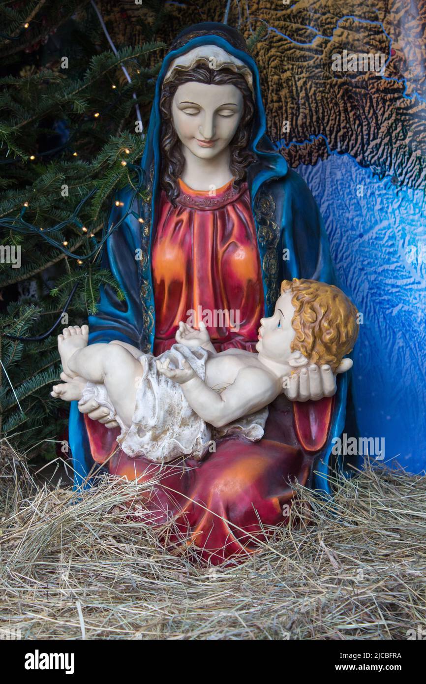 Our Lady holding Jesus on hands in the manger on Christmas Stock Photo