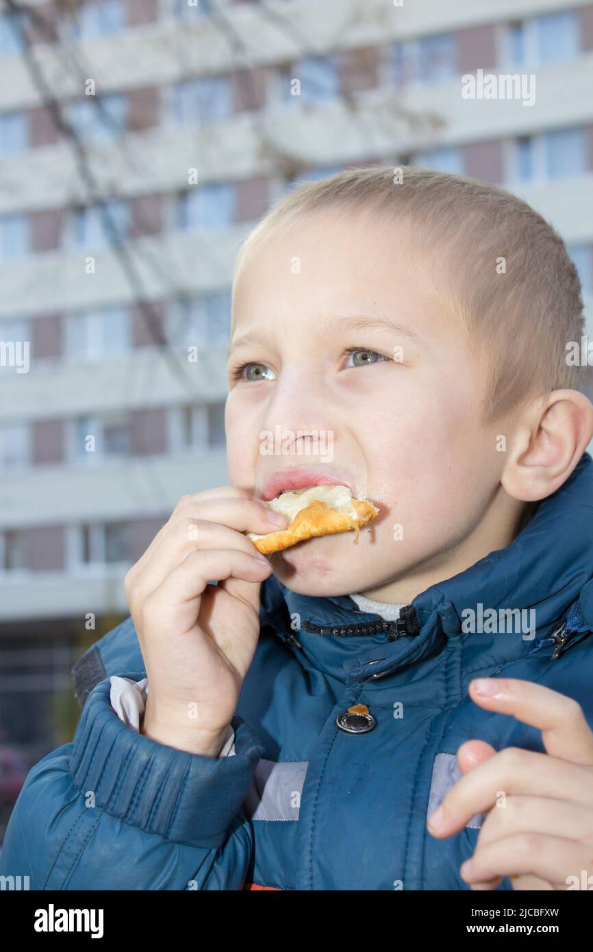 Boy eating hamburger junk food portrait outdoors Stock Photo