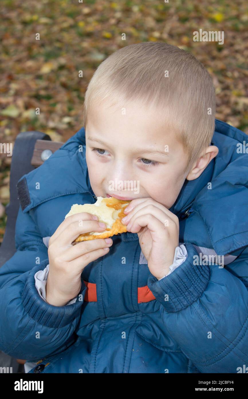 two hands holding a child eats bread Stock Photo