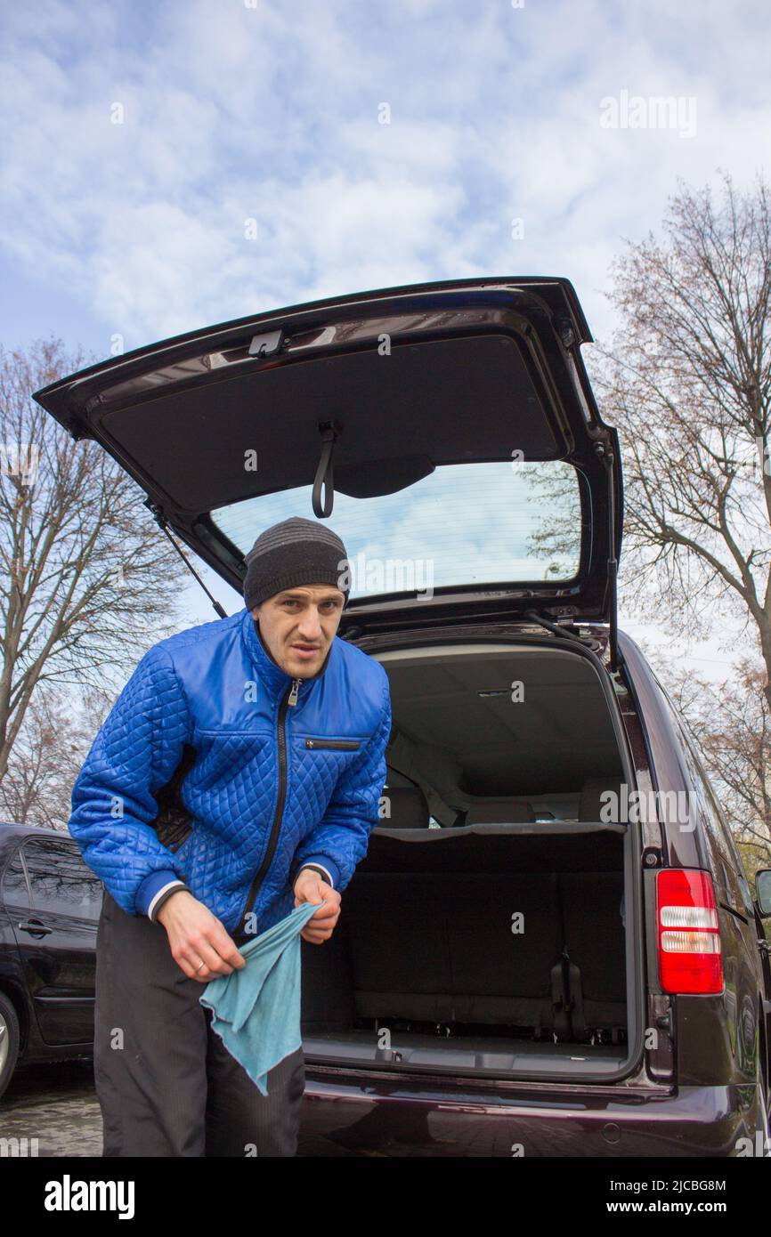 driver standing next to a car with an open trunk Stock Photo Alamy