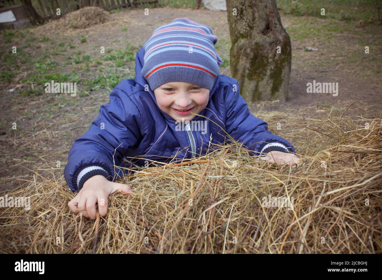 boy playing and climbs on hay on the farm Stock Photo