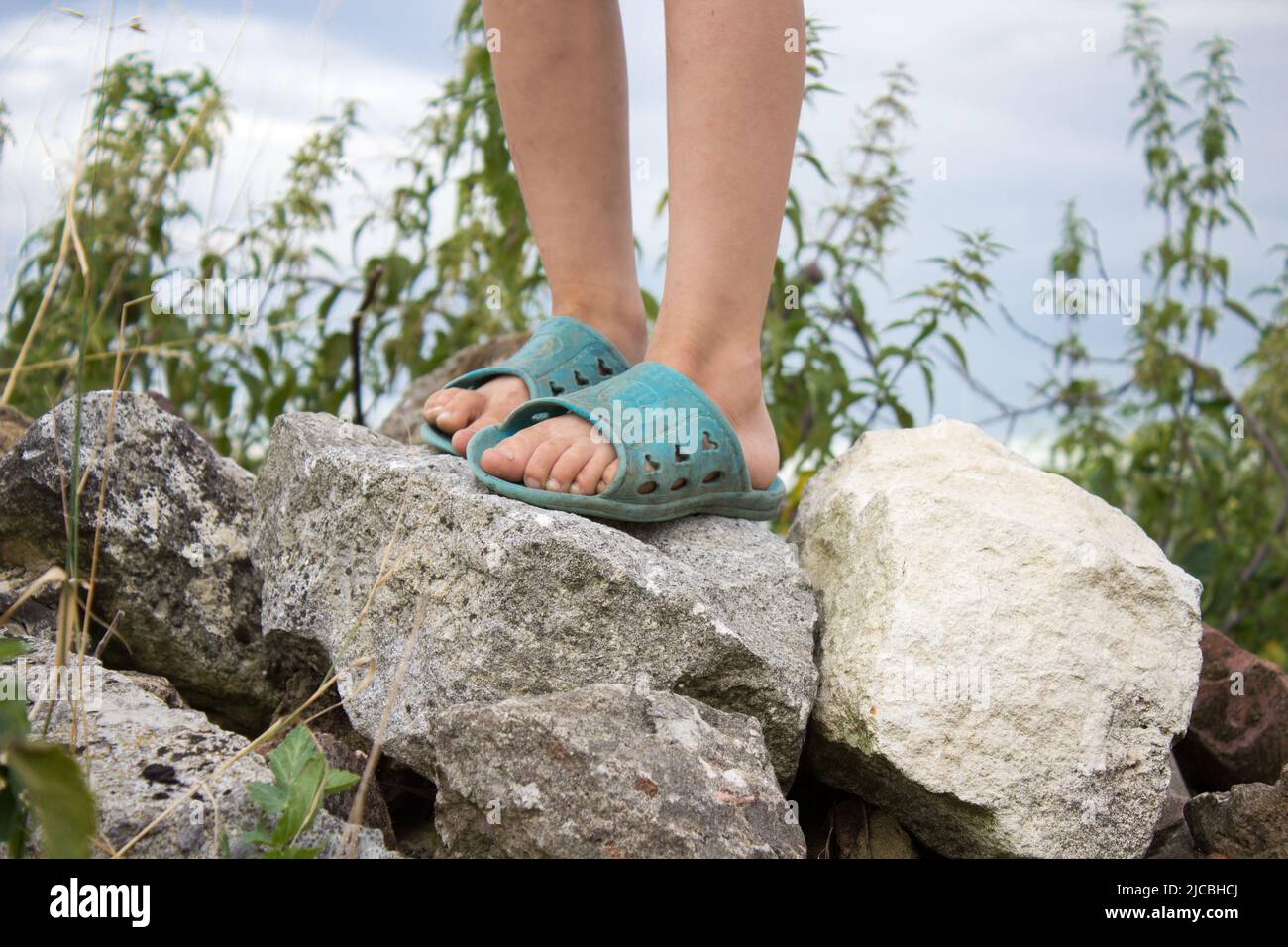 Foot boy standing on a rock in slippers Stock Photo Alamy