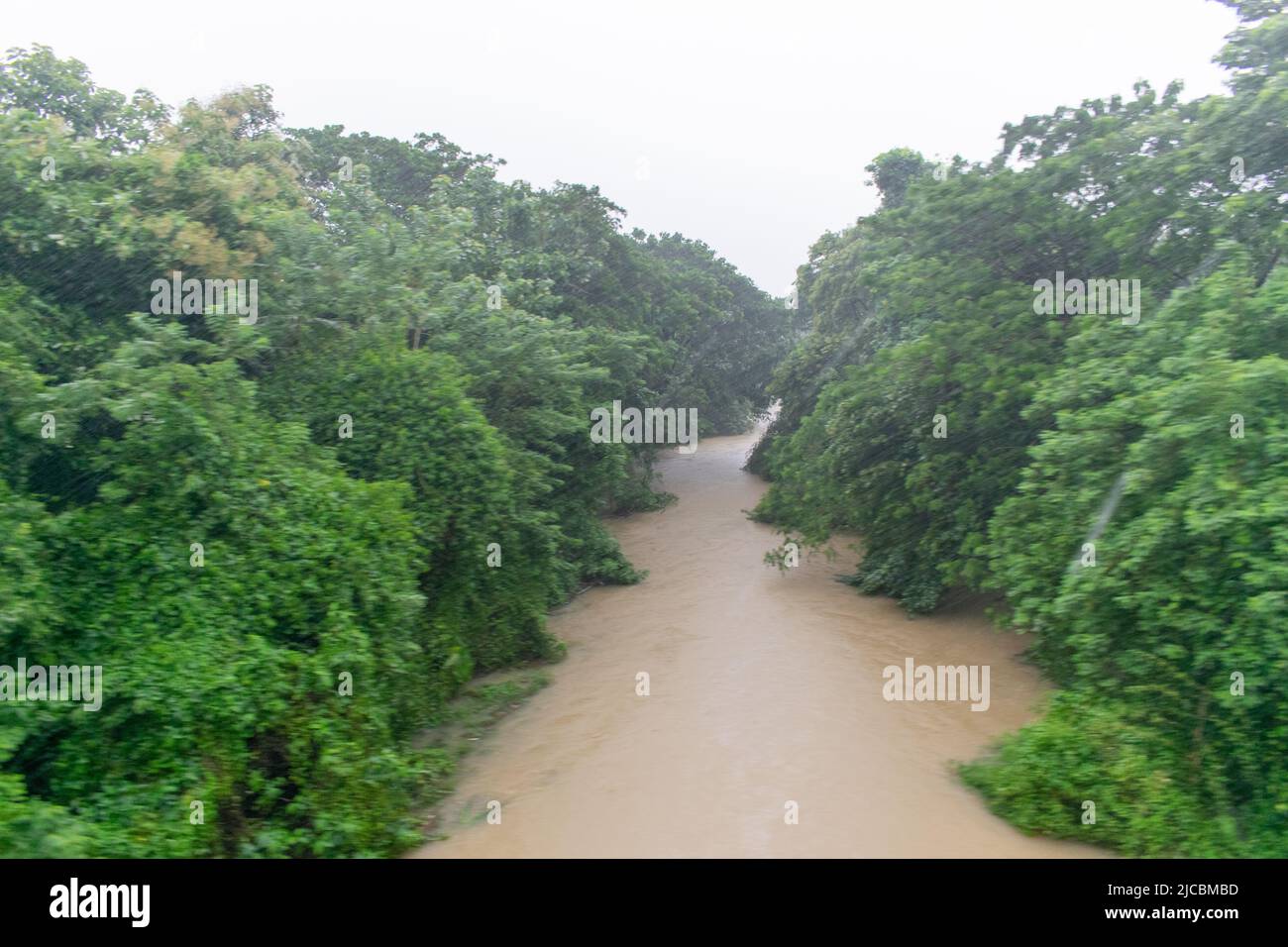 view of a river and it's riverbank during a down pore , pic taken during flood time in India Stock Photo