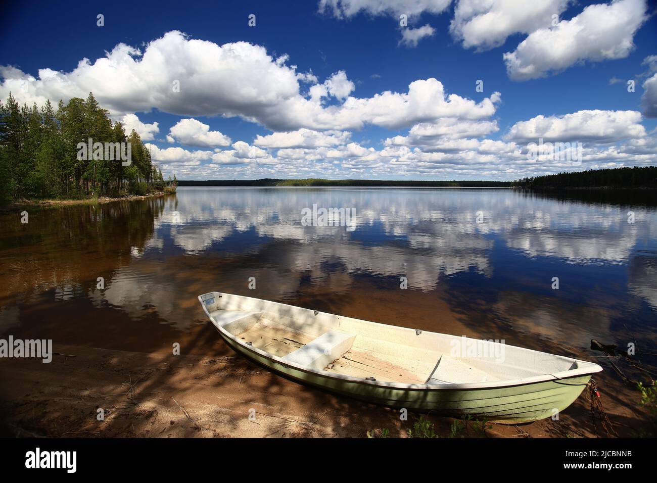 Idyllic view over lake in northern Sweden with rowboat at the beach. Stock Photo