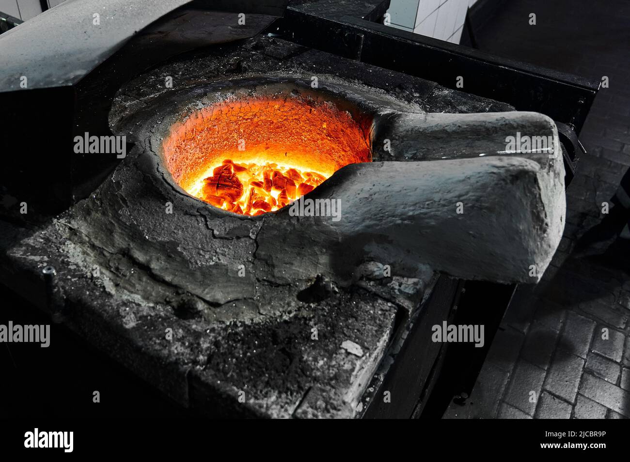 Metal with flux layer in melting pot of inductive furnace Stock Photo