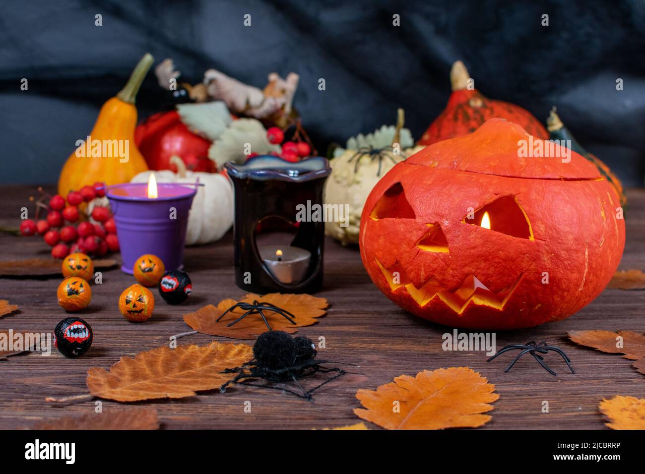 Halloween pumpkins on a wooden dark table with spiders, candles ...