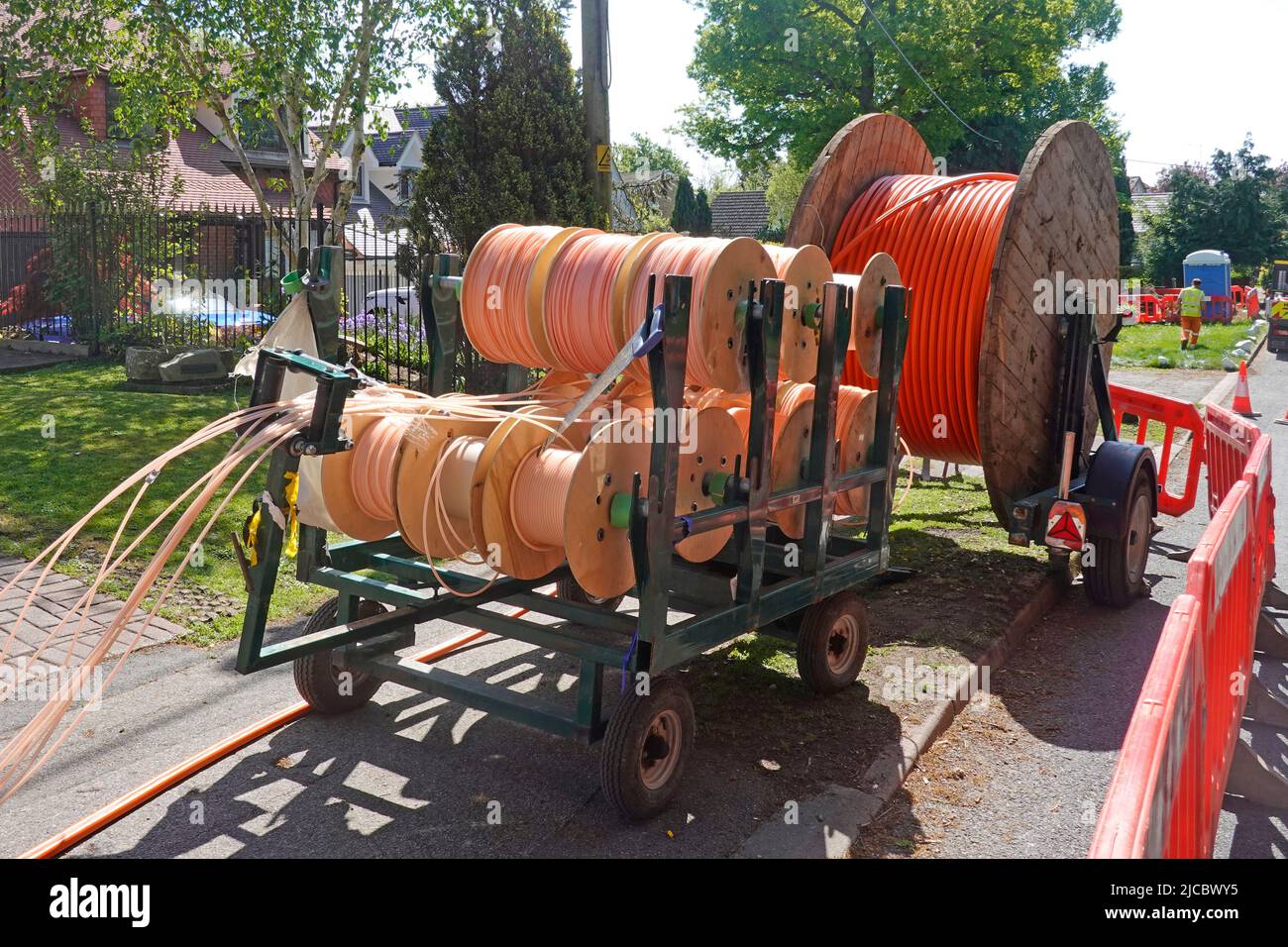 Fibre optic super fast broadband infrastructure project in rural Essex village cables on drums for laying in new shallow pavement trenches England UK Stock Photo