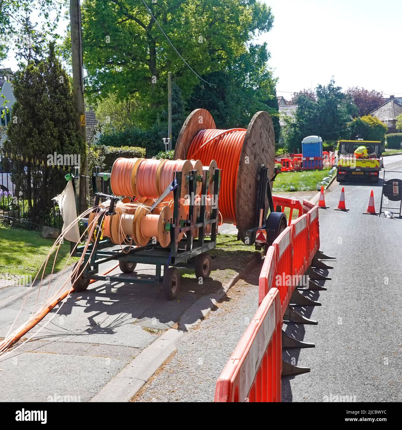 Fibre optics super fast broadband infrastructure project in rural Essex village cables on drums for laying in new shallow pavement trenches England UK Stock Photo