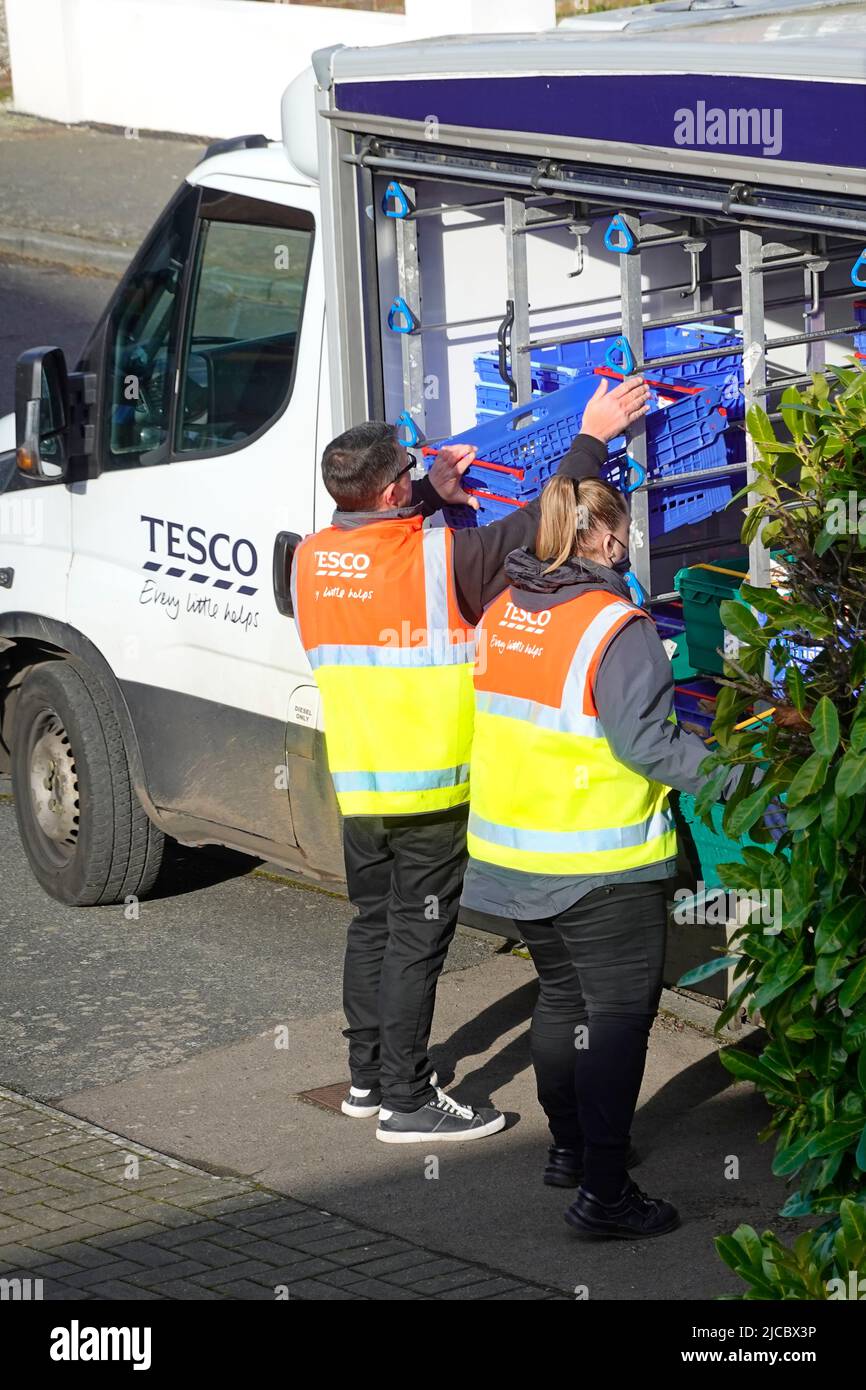 Unusual two Tesco supermarket staff working together assumed training of delivery driver sorting grocery food online shopping order Essex England UK Stock Photo