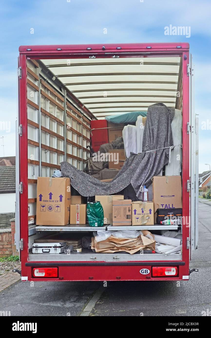Open rear back view into parked long hgv furniture removal lorry truck van showing interior lighting benefit of translucent roof accessing contents UK Stock Photo