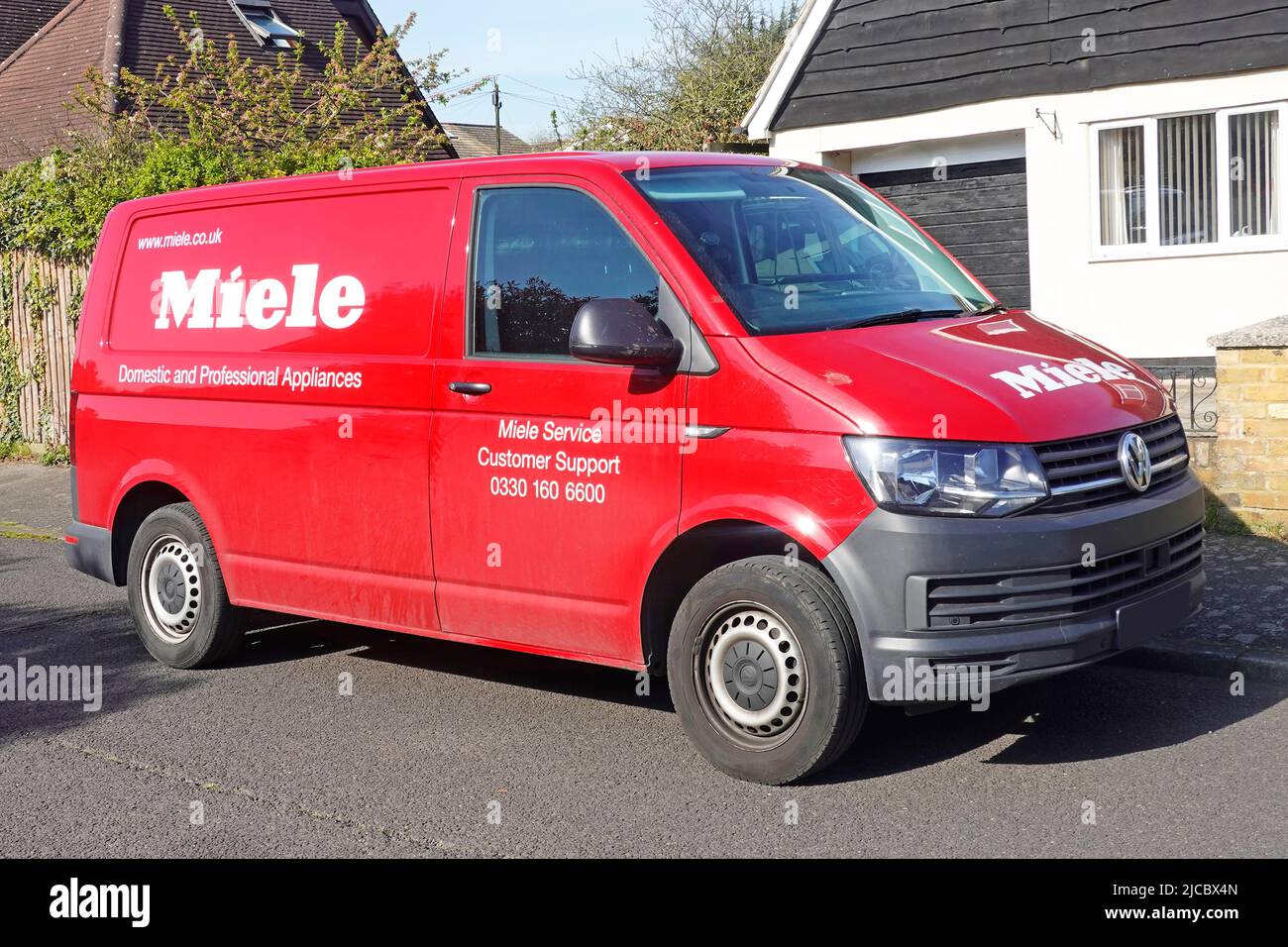 Engineers red Volkswagen VW Miele van for Domestic & Professional appliances bringing customer support parked in residential road Essex England UK Stock Photo