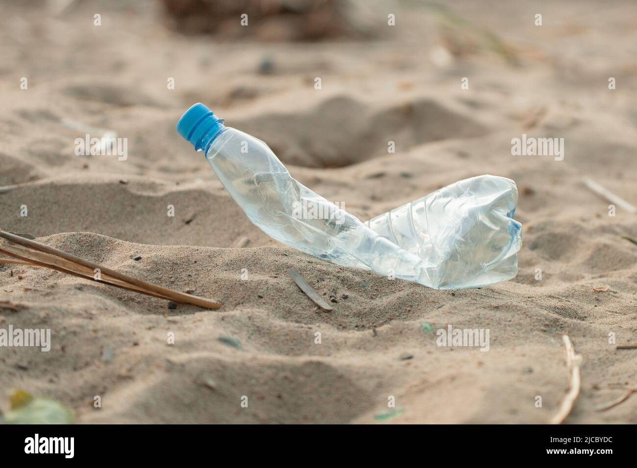 Squashed Plastic Blue old crushed crumpled squashed empty plastic bottle thrown on sandy ...