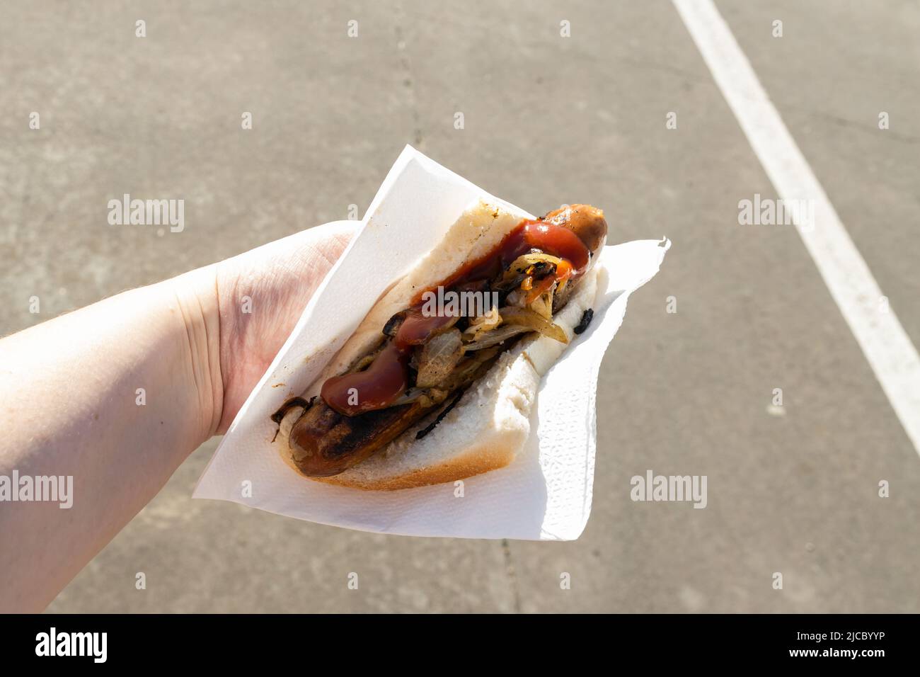 A traditional Australian barbequed sausage in bread with onions and tomato sauce Stock Photo
