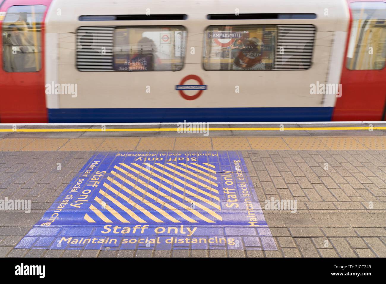 Maintain social distancing yellow box painted on TFL underground platform during covid-19 pandemic England UK Stock Photo