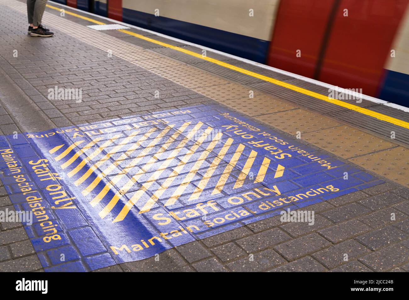Maintain social distancing yellow box painted on TFL underground platform during covid-19 pandemic England UK Stock Photo