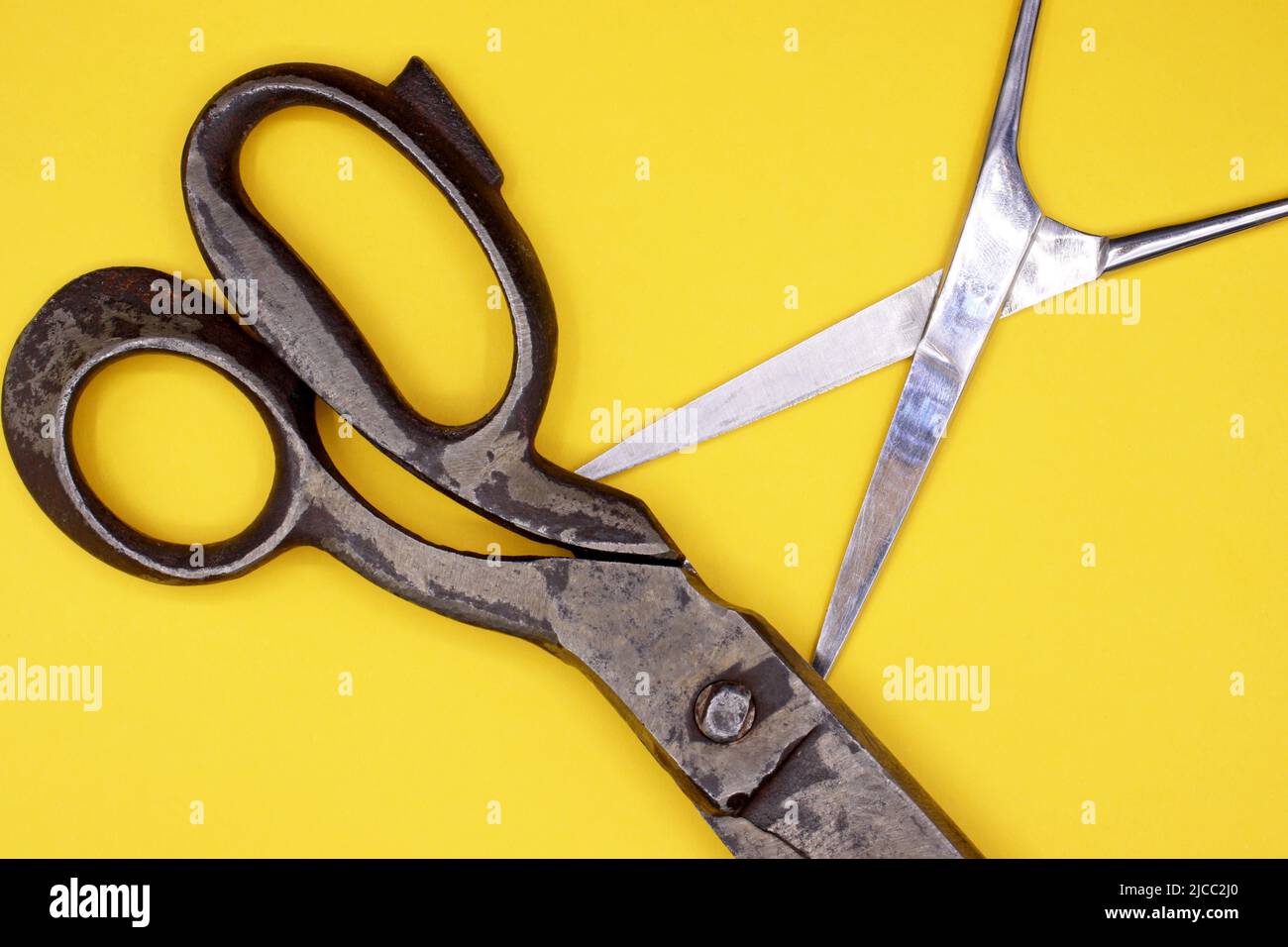 Old scissors on a yellow background Stock Photo