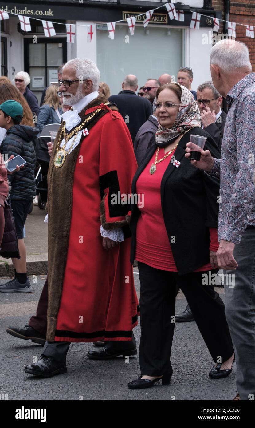 Mayor of Harrow, Cllr Ghazanfar Ali, in official attire, & wife walk on the High Street at St George’s Day Celebration. Pinner, Harrow, London. Stock Photo