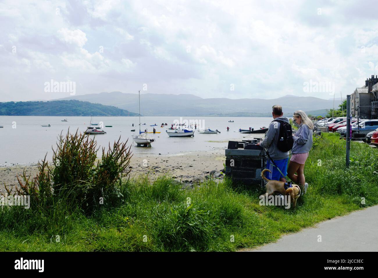 Porthmadog, Wales. Quaint Borth Y Gest village. Tourists look over the picturesque small bay on a summer day.  Landscape aspect shot with copy space. Stock Photo