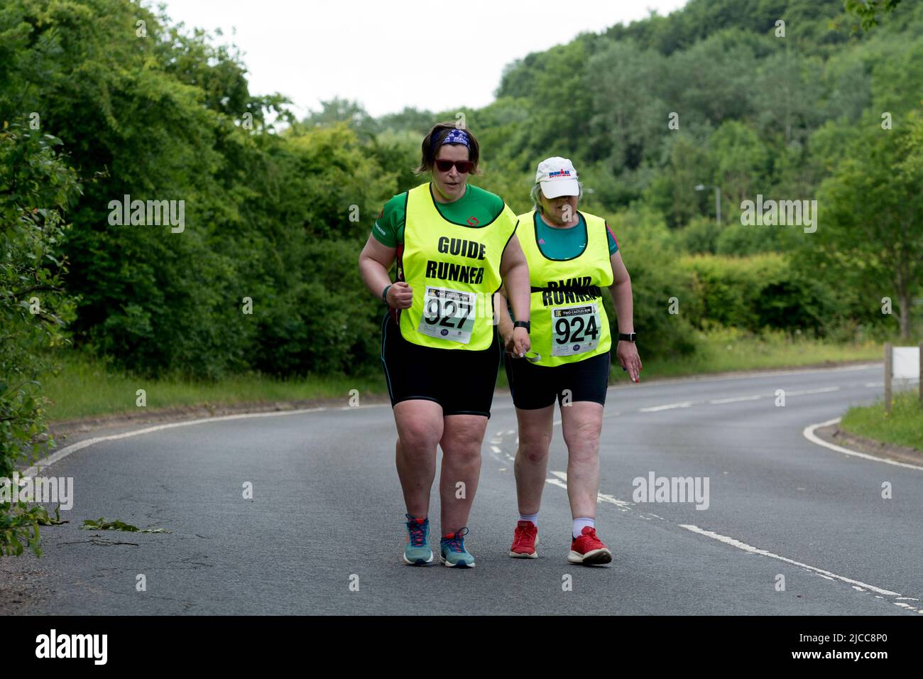 A blind runner and her guide in the 2022 Two Castles 10k road race, Leek Wootton, Warwickshire, UK Stock Photo