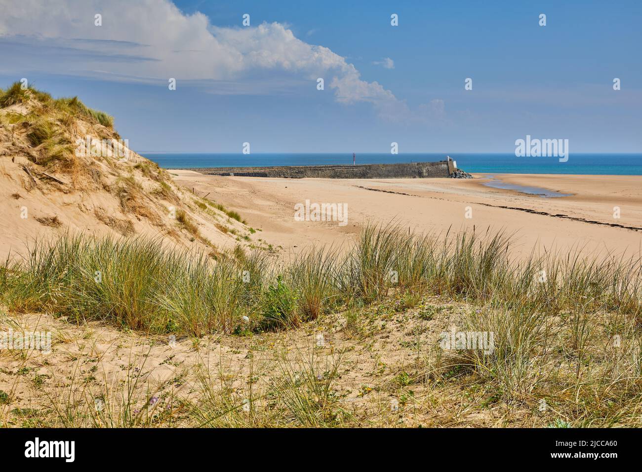 Image of Carteret Plage with sand dunes and the harbour wall Stock Photo