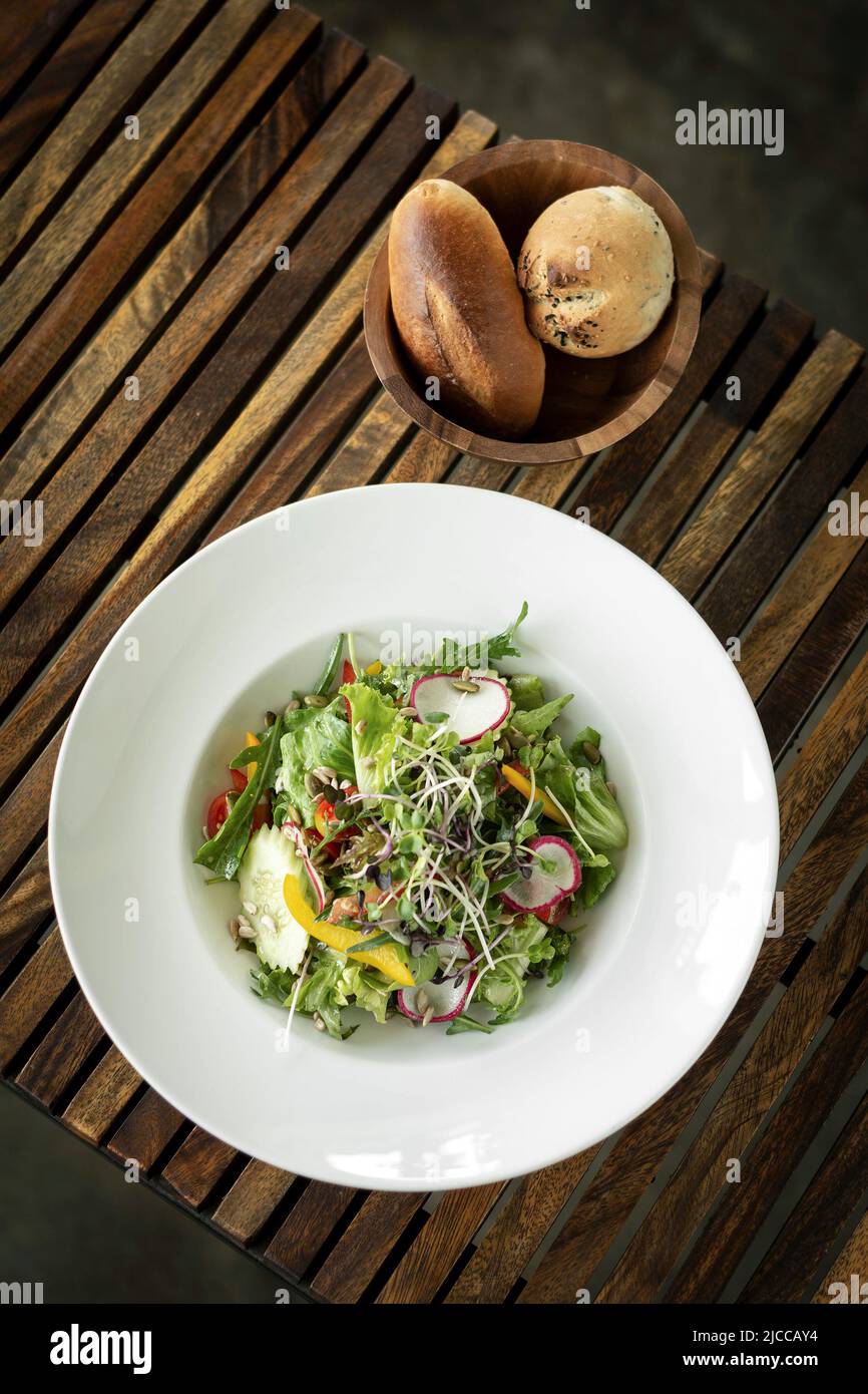 organic mixed vegetable salad with micro greens on wood table Stock Photo