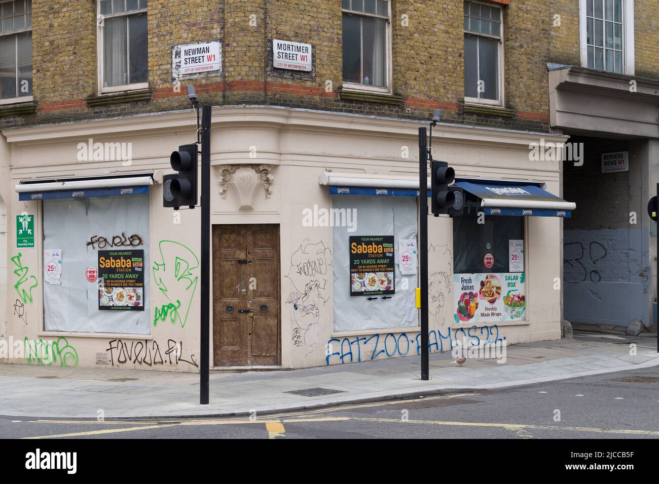 Pedestrians outside closed down and boarded up sandwich shop, Mortimer Street, City of Westminster, London, UK.  5 Jun 2022 Stock Photo
