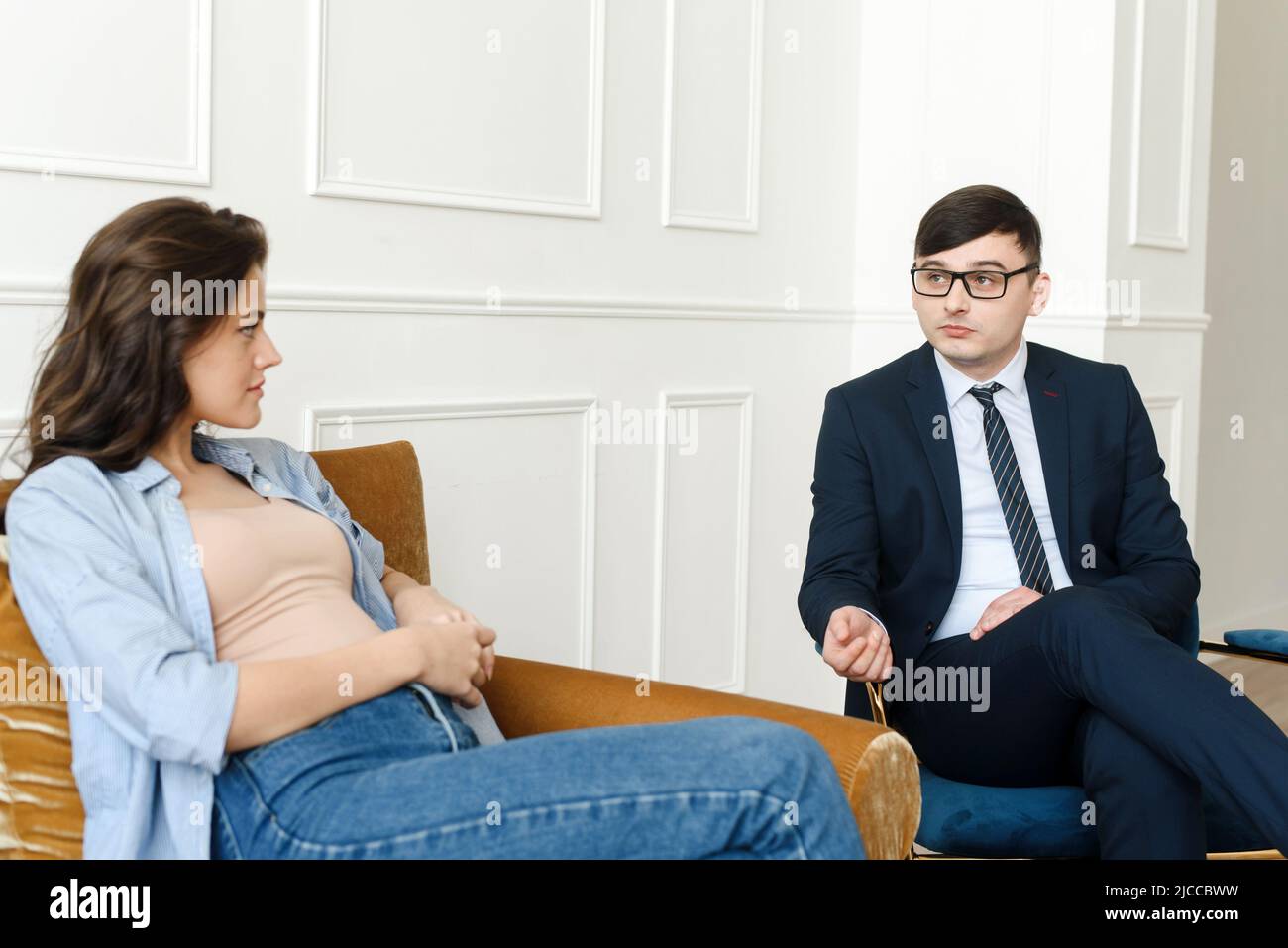 A young worried woman visits a counseling therapist. The girl feels depressed, unhappy and hopeless, needs help. Unwanted pregnancy, abortion or death Stock Photo