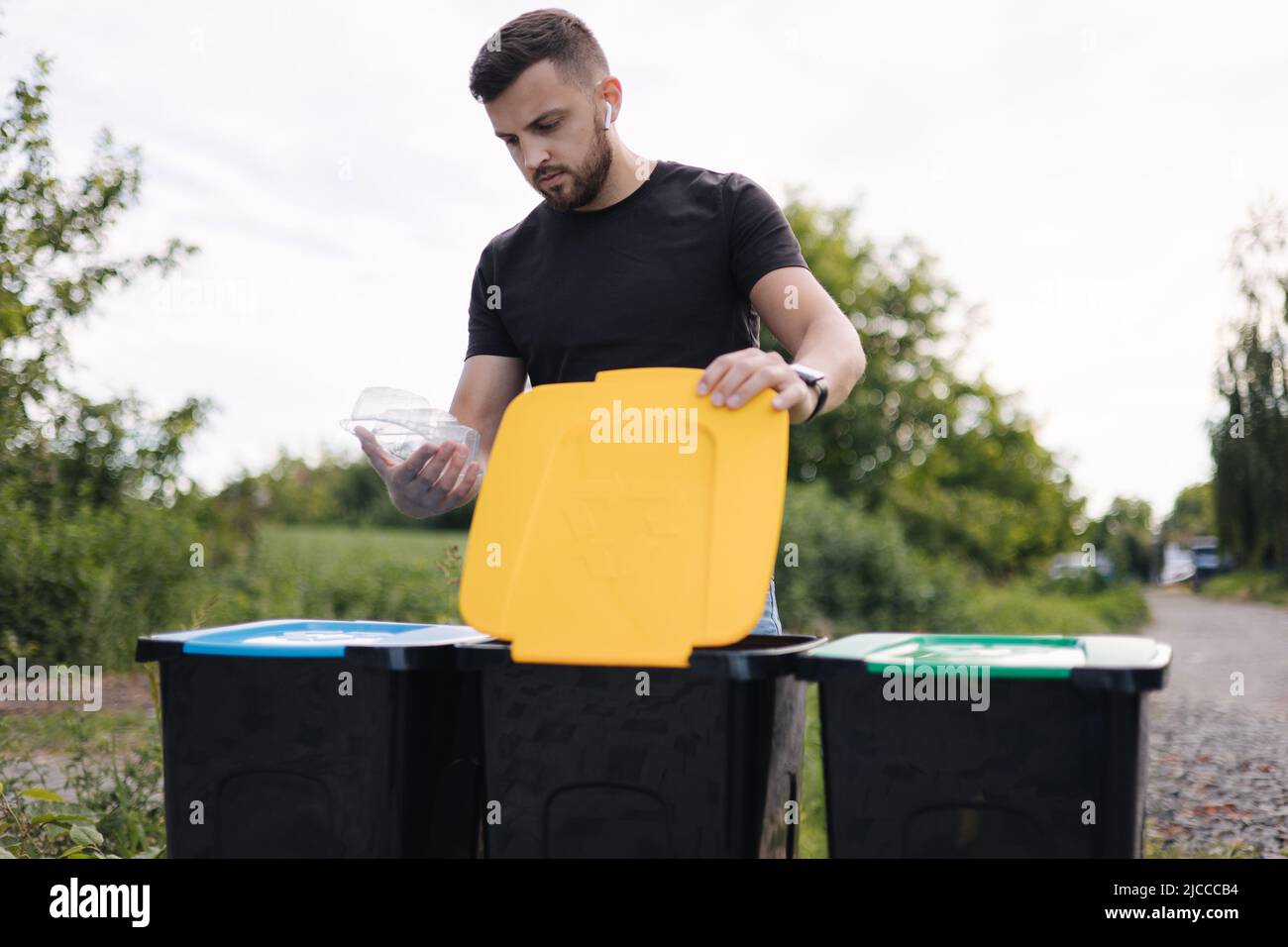 Man throwing out in recycling bin clean empty plastic container