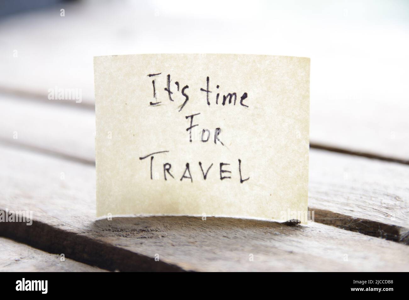 It's travel time. Paper card with an inscription. Summer Vacations idea. Stock Photo